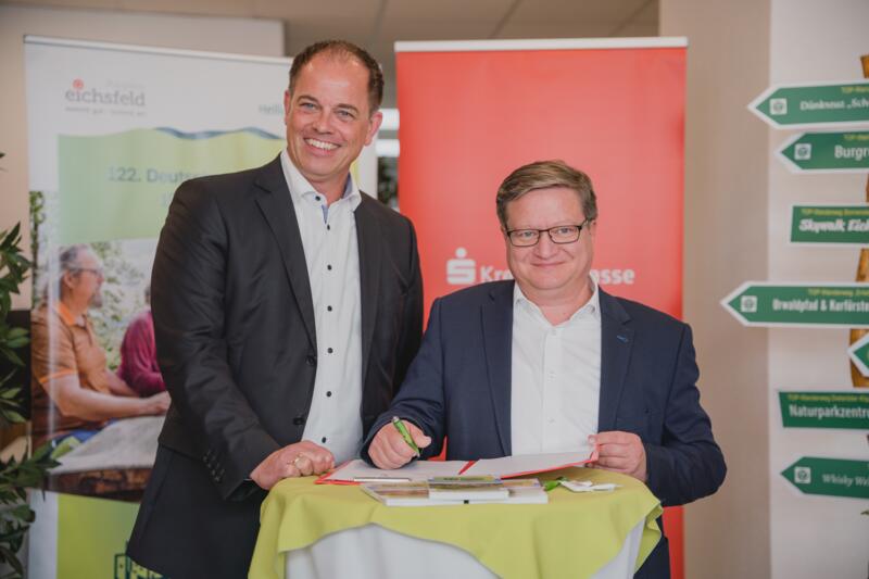 Vorstandsvorsitzender der Kreissparkasse Eichsfeld Steffen-Peter Horn (links) und Bürgermeister Thomas Spielmann bei der Unterzeichnung des Sponsorenvertrags